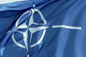 Blaue Flagge mit weißem NATO-Symbol
