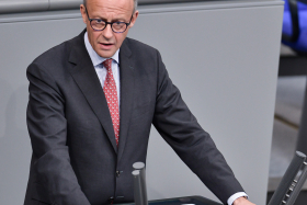 Friedrich Merz im Deutschen Bundestag. Er steht am Rednerpult mit der Aufschrift Deutscher Bundestag und hält eine Rede.