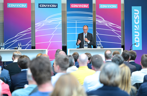 Kirchenkongress der CDU/CSU Fraktion. Friedrich Merz spricht am Rednerpult. Im Vordergrund das Publikum des Kongresses in der Rückansicht.
