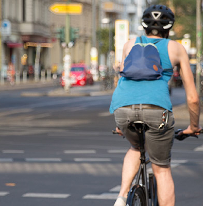 Drei Fahrradfahrer überqueren eine innerstädtische Kreuzung